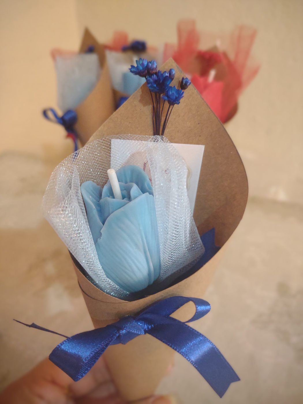Vela em formato de rosa azul, embrulhada como buquê individual