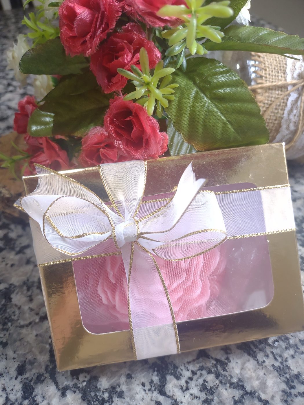 Vela em formato de rosa em caixa dourada com laço