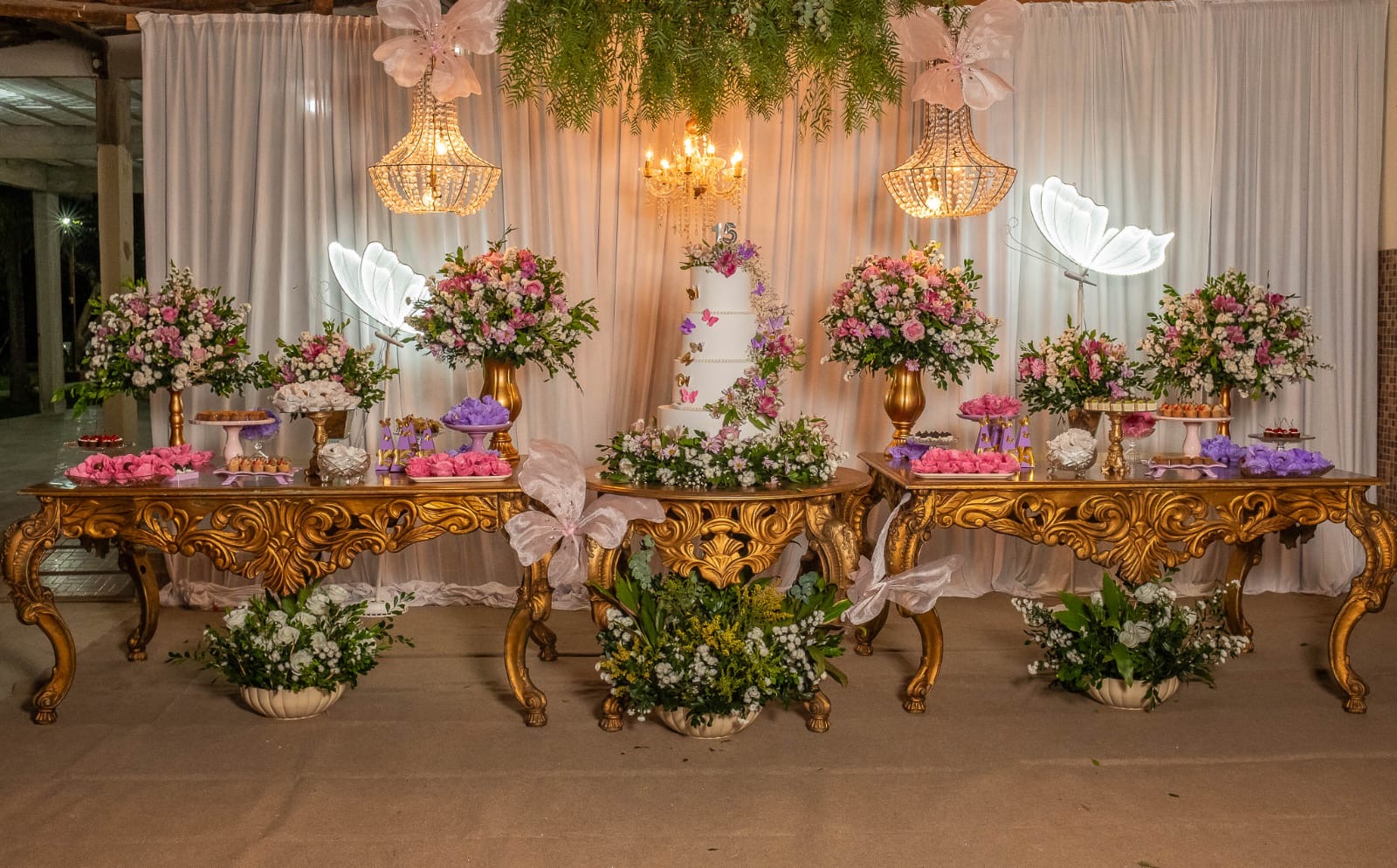 Mesa de doces de festa de 15 anos com forminhas em tons de rosa e lilás